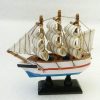 Petit voilier multicolore trois mats voiles blanches