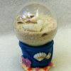Boule flamant rose ou coquillages dans le seau de sable